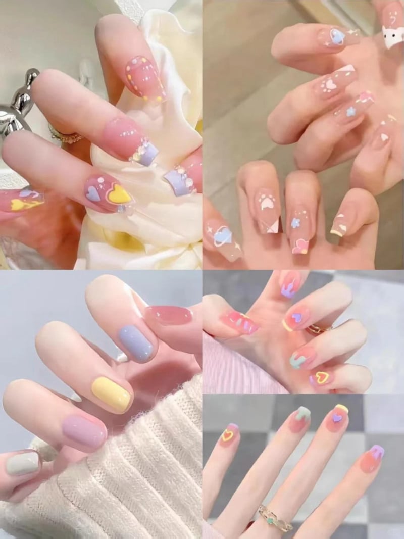 Bộ móng tay trang trí với nhiều màu sắc và họa tiết khác nhau, bao gồm trái tim và hoa văn sáng tạo.