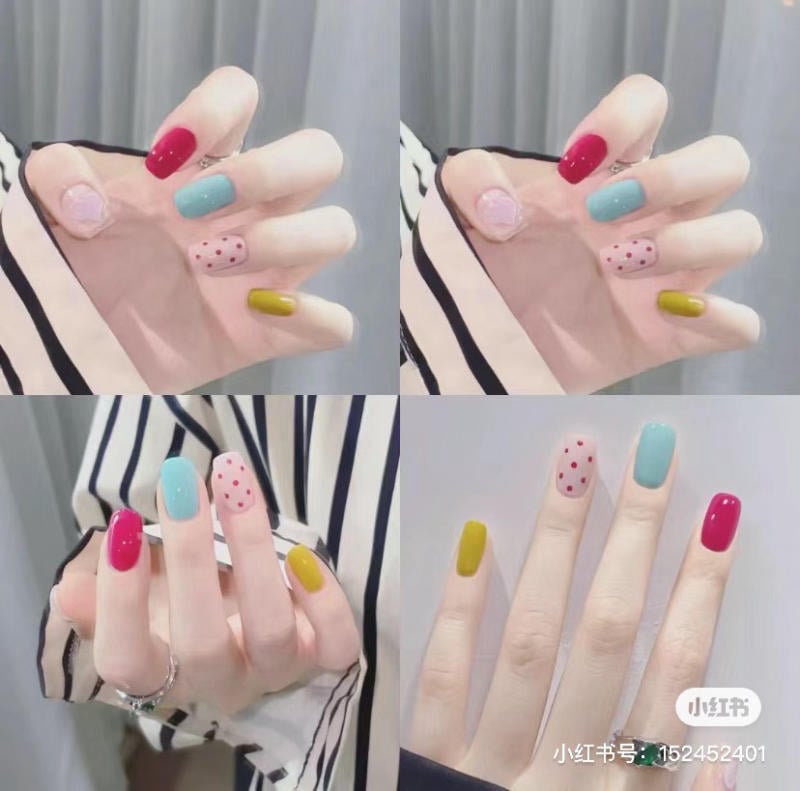Bộ móng tay sơn màu sắc đa dạng: đỏ, xanh, vàng, và chấm bi, trên nền áo sọc trắng đen.