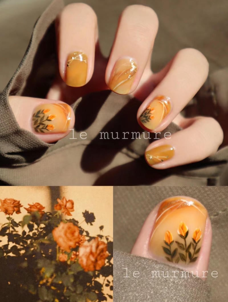 Bộ m&oacute;ng tay nghệ thuật m&agrave;u cam với họa tiết hoa l&aacute;, kết hợp c&ugrave;ng bức ảnh hoa hồng cam.