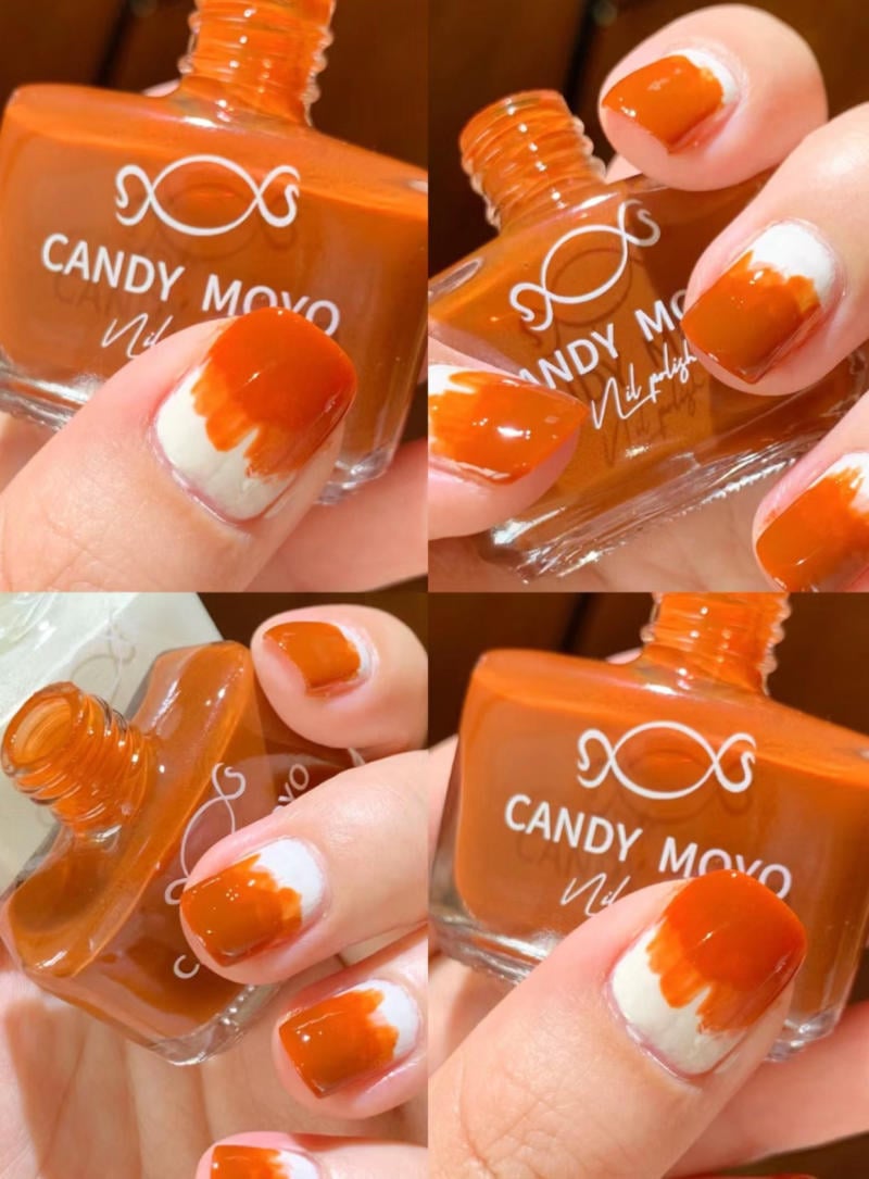 B&agrave;n tay với m&oacute;ng sơn m&agrave;u cam, lọ sơn m&oacute;ng tay m&agrave;u cam b&ecirc;n cạnh, thương hiệu in tr&ecirc;n chai.