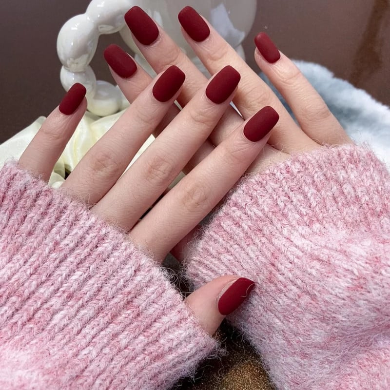 nail-mau-do-do-cardina-3-jpg_2537ee6ada214799bc9cbb444b719c0b Hai bàn tay với móng tay sơn màu đỏ mận đậm, mặc áo len màu hồng nhạt, đặt gần nhau.