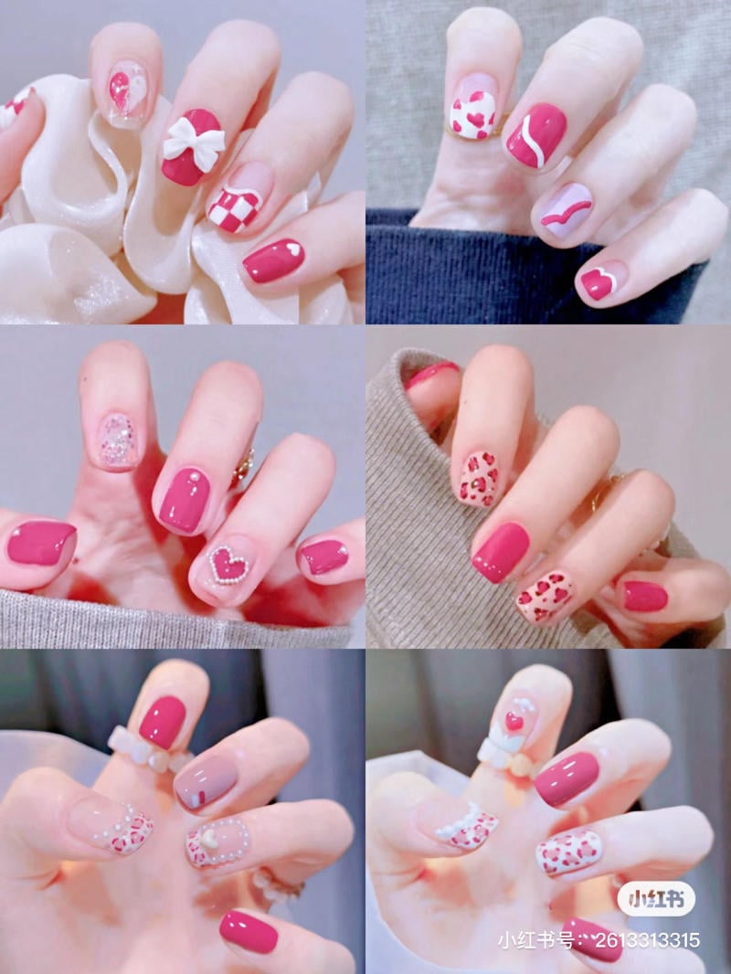 Bộ sưu tập móng tay nghệ thuật với nhiều họa tiết trái tim và nơ trên nền màu hồng và đỏ.