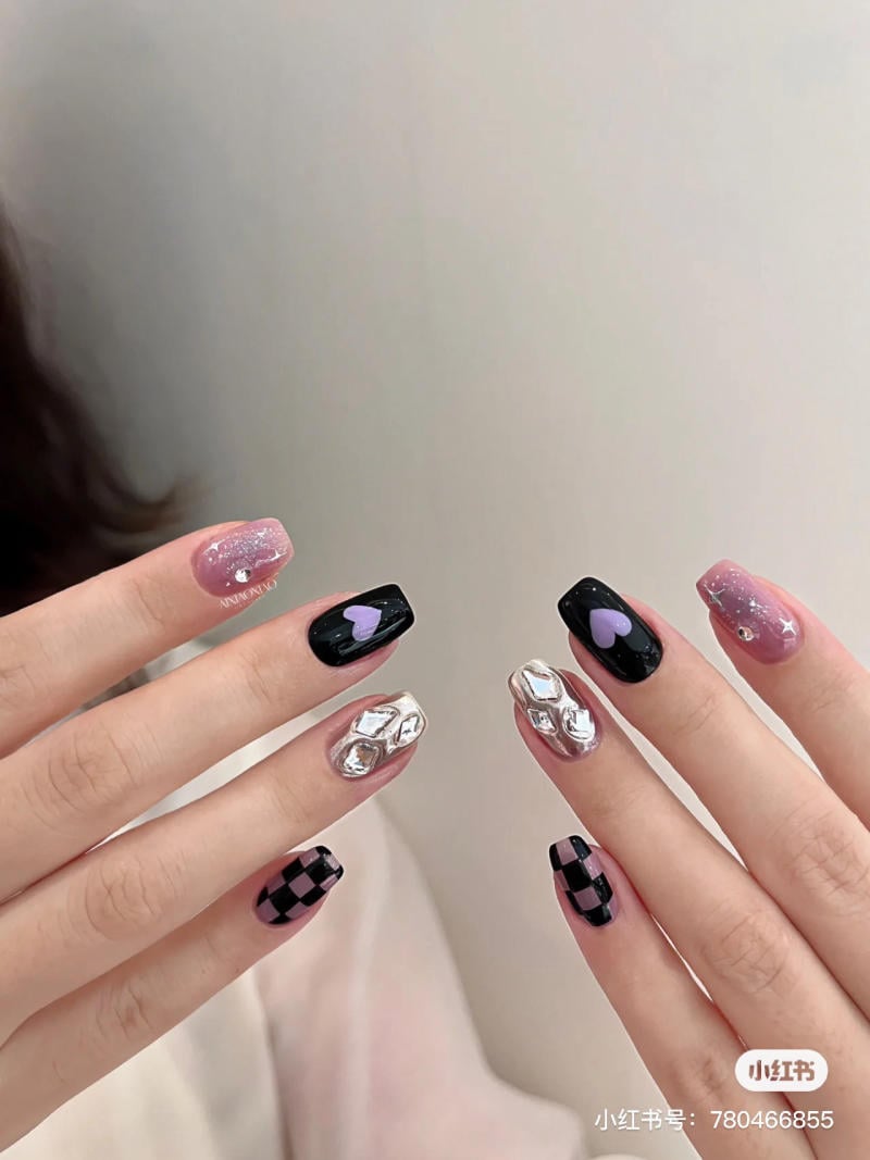 nail-mau-tim__4__f4d03e879cad40309b0708e70bd09d3a Bàn tay với móng tay trang trí đa dạng gồm màu đen, hồng nhạt, họa tiết caro và trang trí kim loại.