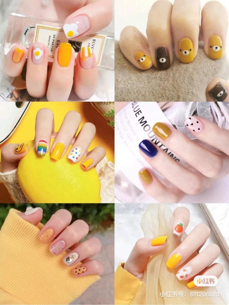Bộ sưu tập móng tay trang trí với nhiều hình vẽ và màu sắc khác nhau, chủ yếu là màu vàng và họa tiết sáng tạo.
