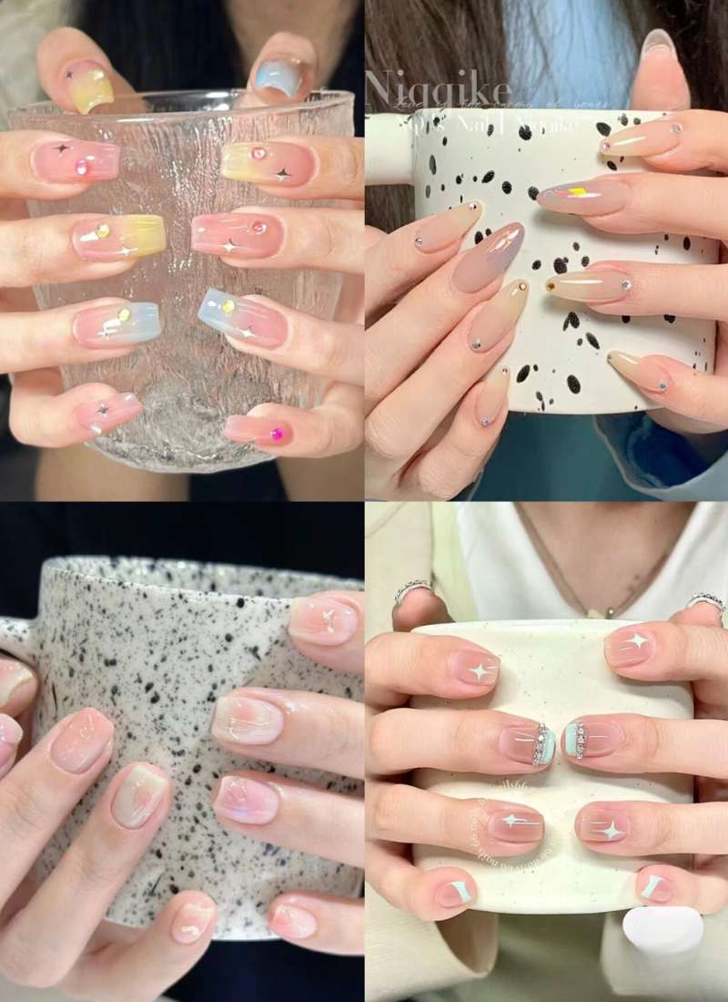 Bốn kiểu móng tay nghệ thuật với nhiều màu sắc và họa tiết khác nhau, mỗi kiểu cầm một chiếc cốc khác nhau.
