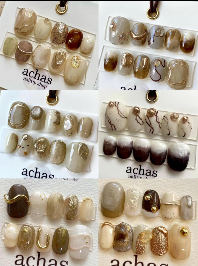 Bộ sưu tập móng giả với các họa tiết màu sắc khác nhau, từ nâu nhạt đến nâu đậm, có chi tiết kim loại.