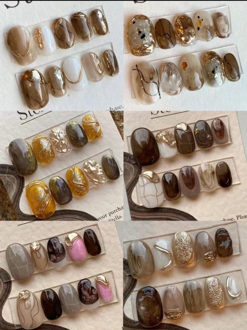 Bộ sưu tập móng tay giả với nhiều màu sắc và họa tiết khác nhau, bao gồm nâu, vàng, và hồng nhũ.