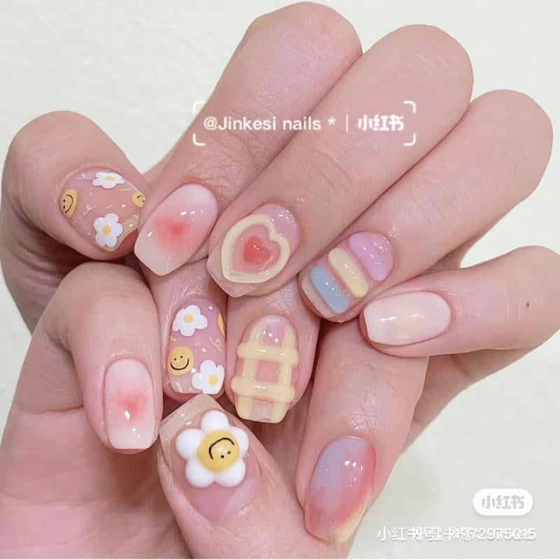 Bàn tay với móng tay được trang trí họa tiết hoa, trái tim và màu sắc pastel đa dạng.