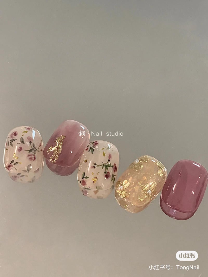 Bộ m&oacute;ng giả trang tr&iacute; hoa v&agrave; v&agrave;ng l&aacute; tr&ecirc;n nền m&agrave;u hồng v&agrave; trong suốt, sắp xếp th&agrave;nh một h&agrave;ng ngang.