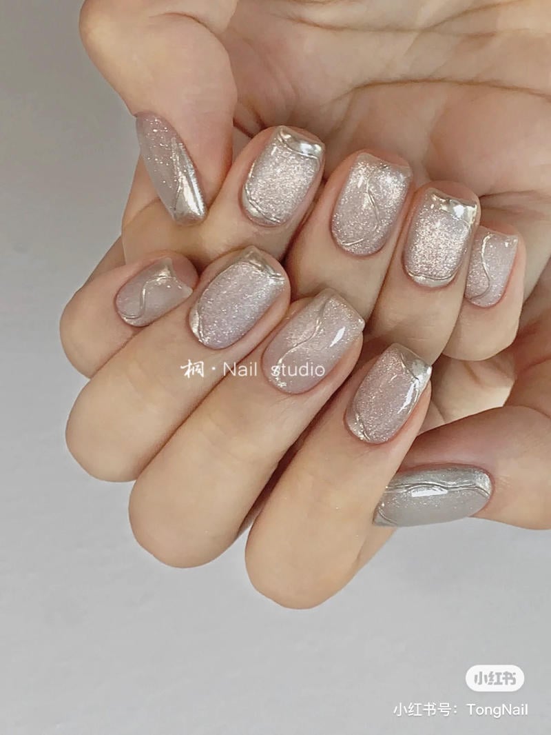 B&agrave;n tay với m&oacute;ng tay sơn m&agrave;u bạc lấp l&aacute;nh, thiết kế trang tr&iacute; tinh tế v&agrave; hiện đại.