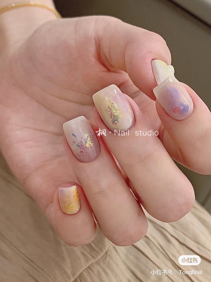 B&agrave;n tay với m&oacute;ng được trang tr&iacute; nghệ thuật, m&agrave;u pastel, c&oacute; họa tiết v&agrave; &aacute;nh kim loại.