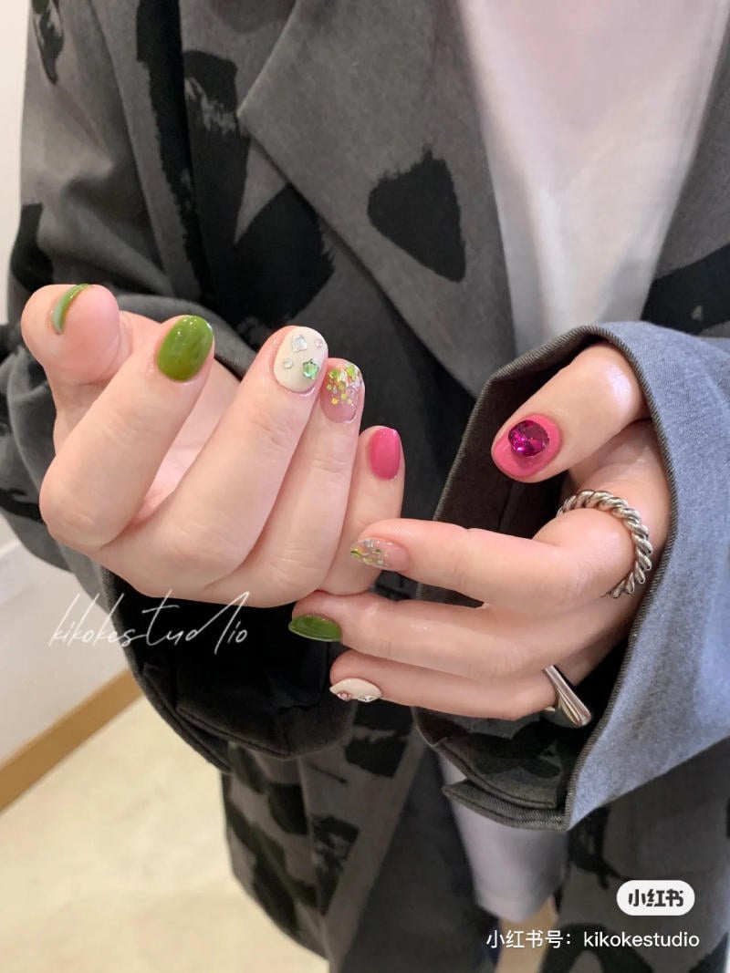 B&agrave;n tay với m&oacute;ng tay được sơn m&agrave;u sắc kh&aacute;c nhau v&agrave; trang tr&iacute; họa tiết s&aacute;ng tạo.