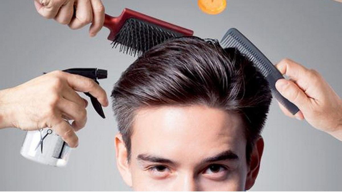 Người đàn ông được tạo kiểu tóc với lược, bàn chải và bình xịt, tập trung vào mái tóc gọn gàng.