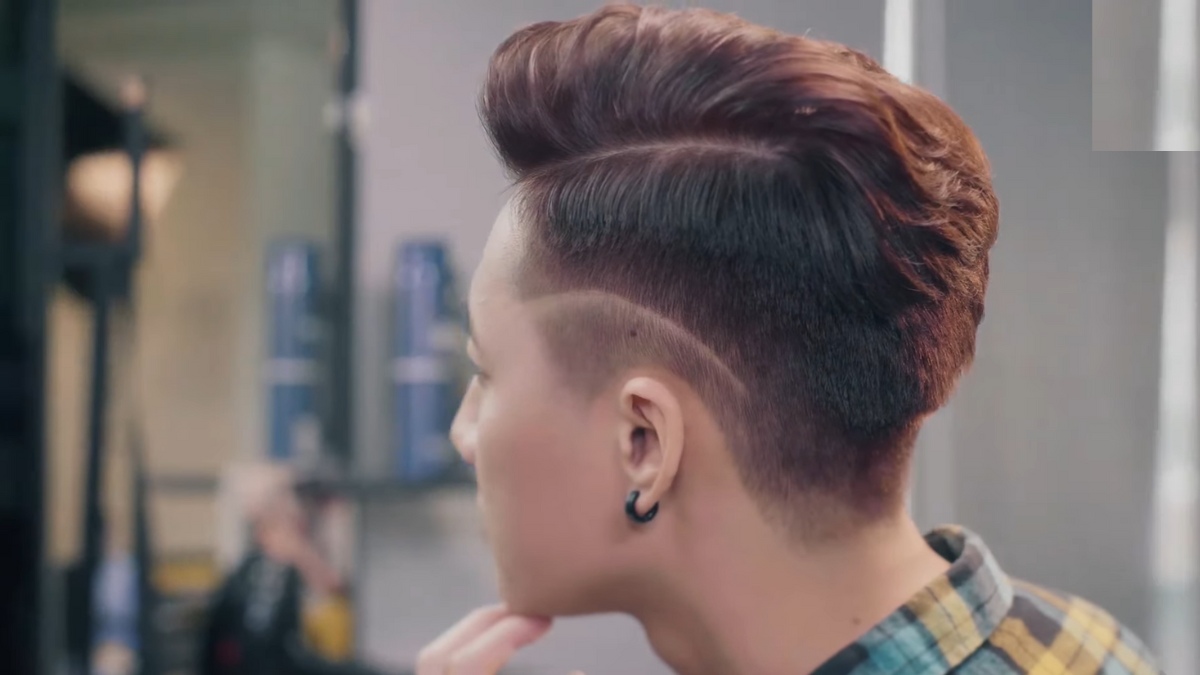 Người đang ngồi trong tiệm cắt tóc với kiểu tóc undercut, nhìn từ phía sau.