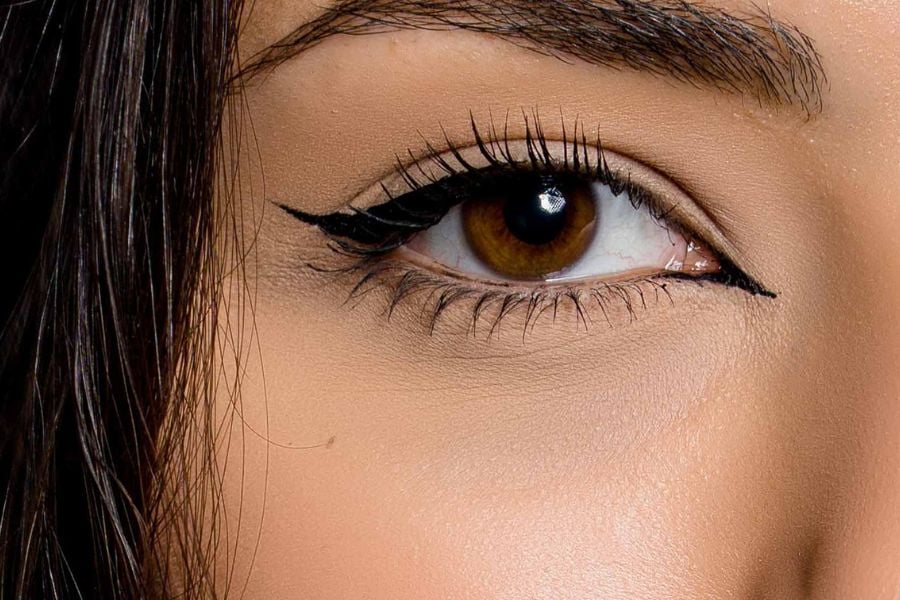 Cận cảnh một mắt người với trang điểm eyeliner đậm và lông mày tự nhiên.