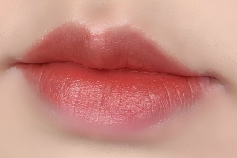 Cận cảnh đôi môi trang điểm màu hồng đỏ, bề mặt mịn màng và căng mọng.