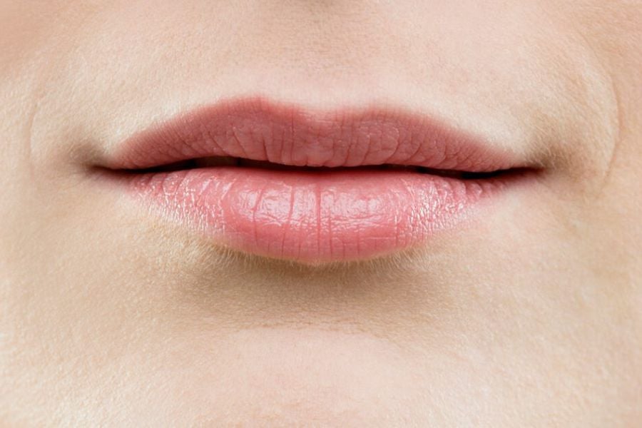 Đôi môi người đang mím nhẹ, da xung quanh mịn màng, ánh sáng tự nhiên.