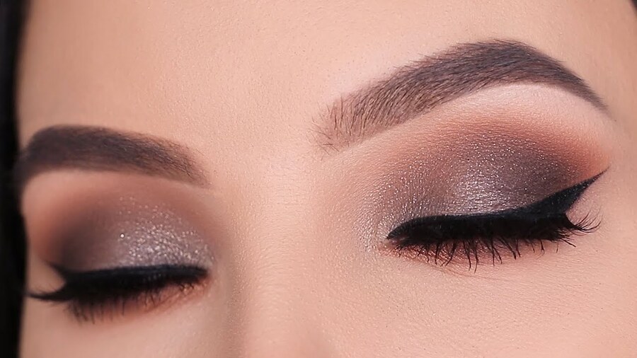 Đôi mắt trang điểm với phấn mắt nâu và eyeliner đen, lông mày được kẻ sắc nét.