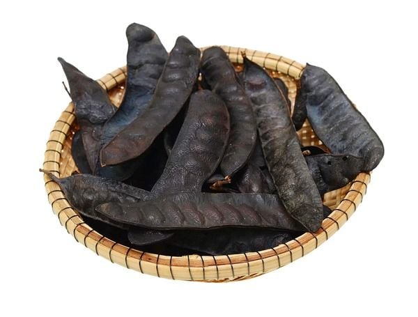 Giỏ tre đựng nhiều trái bồ kết khô màu đen, bề mặt nhăn nheo, được sắp xếp gọn gàng.
