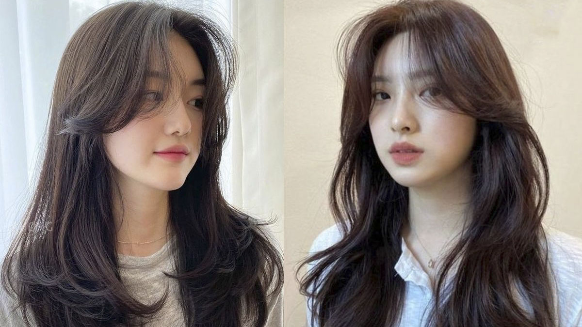 cach-cat-toc-layer-tai-nha-3 Hai người với kiểu tóc dài, uốn nhẹ, tạo kiểu tự nhiên, đứng trước nền sáng và nền trung tính.