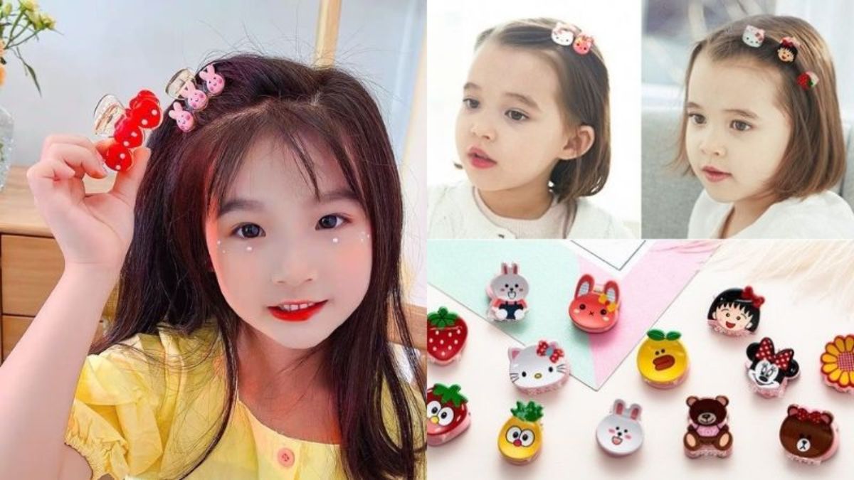Các bé gái đeo kẹp tóc hình thú và trái cây đáng yêu, với nhiều mẫu kẹp khác nhau được bày trên bàn.