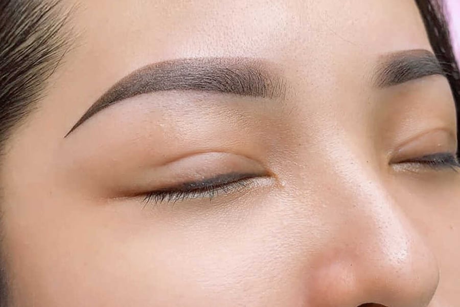 Cận cảnh đôi mắt và lông mày được trang điểm kỹ lưỡng, mắt nhắm nhẹ nhàng, lông mày sắc nét và đều.
