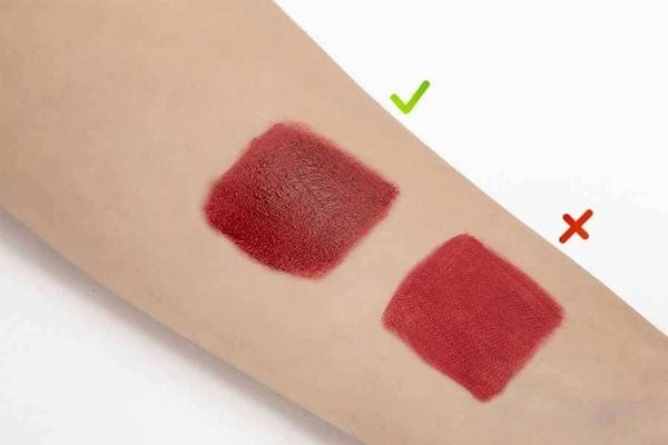 Hai mẫu son đỏ trên cánh tay, mẫu bên trái có dấu tích xanh và mẫu bên phải có dấu nhân đỏ.