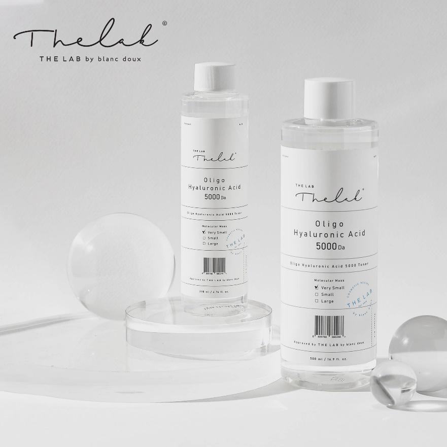 Hai chai dung dịch axit hyaluronic tr&ecirc;n nền trắng, với c&aacute;c chi tiết trang tr&iacute; xung quanh.