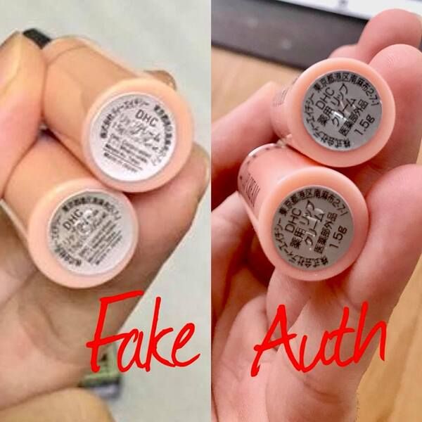kiem_tra_qua_tem_duoi_day_son_293dd8ffe4884daaa87653cb5a4a8ea4_grande Hai tay cầm sản phẩm hình trụ màu hồng nhạt có nhãn tiếng Nhật, được chú thích "Fake" và "Auth".