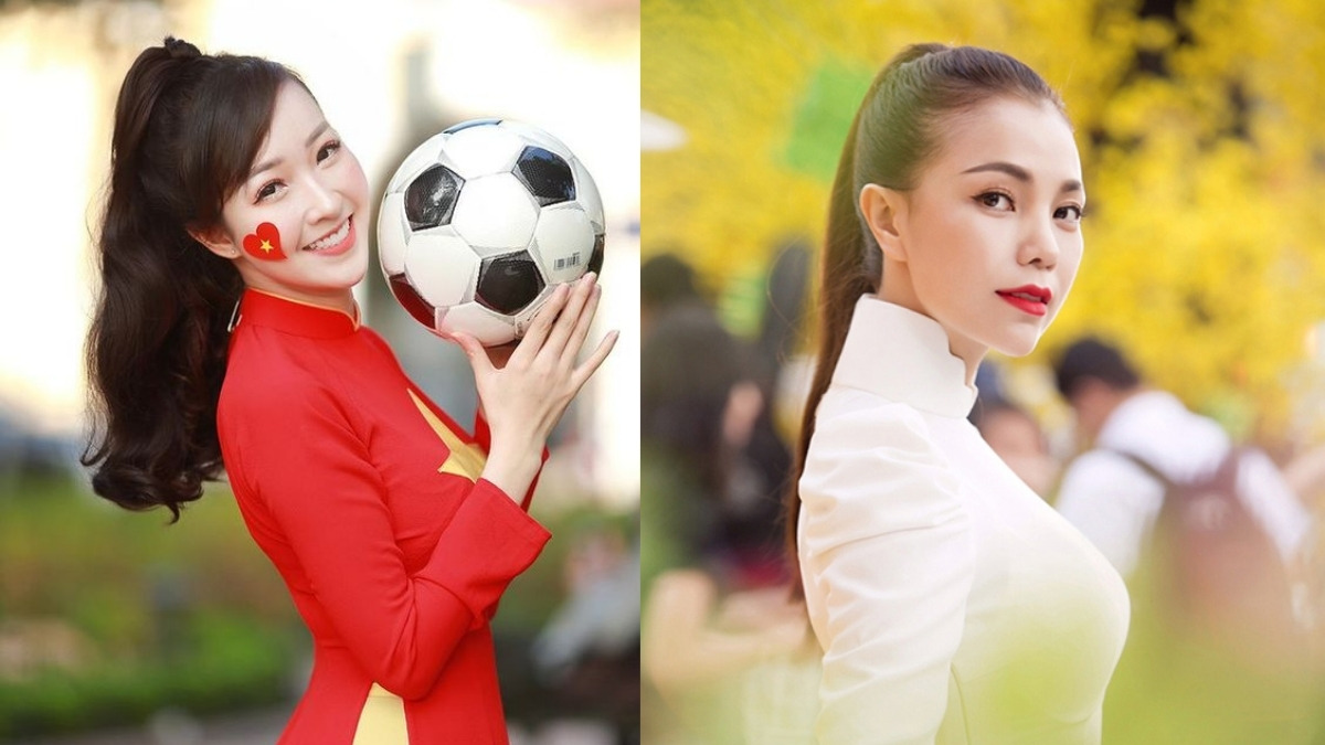 Một người mặc áo dài đỏ cầm bóng đá, và một người khác mặc áo dài trắng, đứng trước nền cây cối và người qua lại.