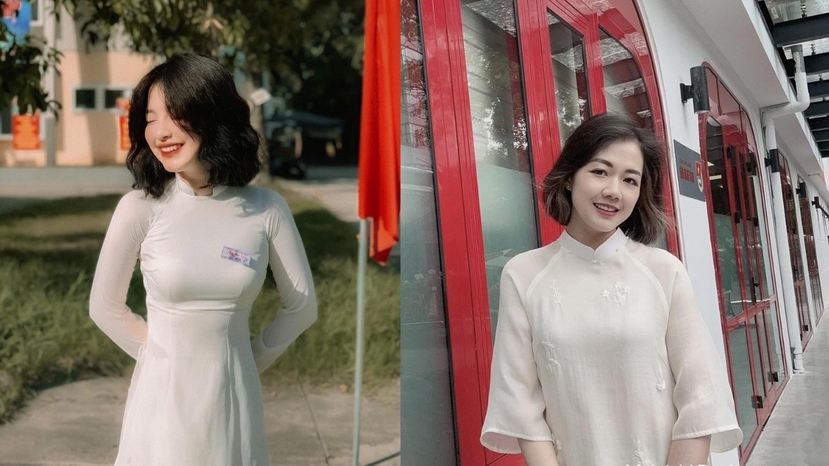 Hai người mặc áo dài trắng, đứng trước cảnh ngoài trời và cửa kính, cười tươi.