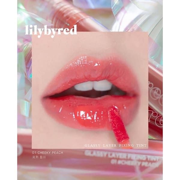 Đôi môi đang thoa son bóng màu hồng cam, nền là các ống son và chữ "lilybyred".