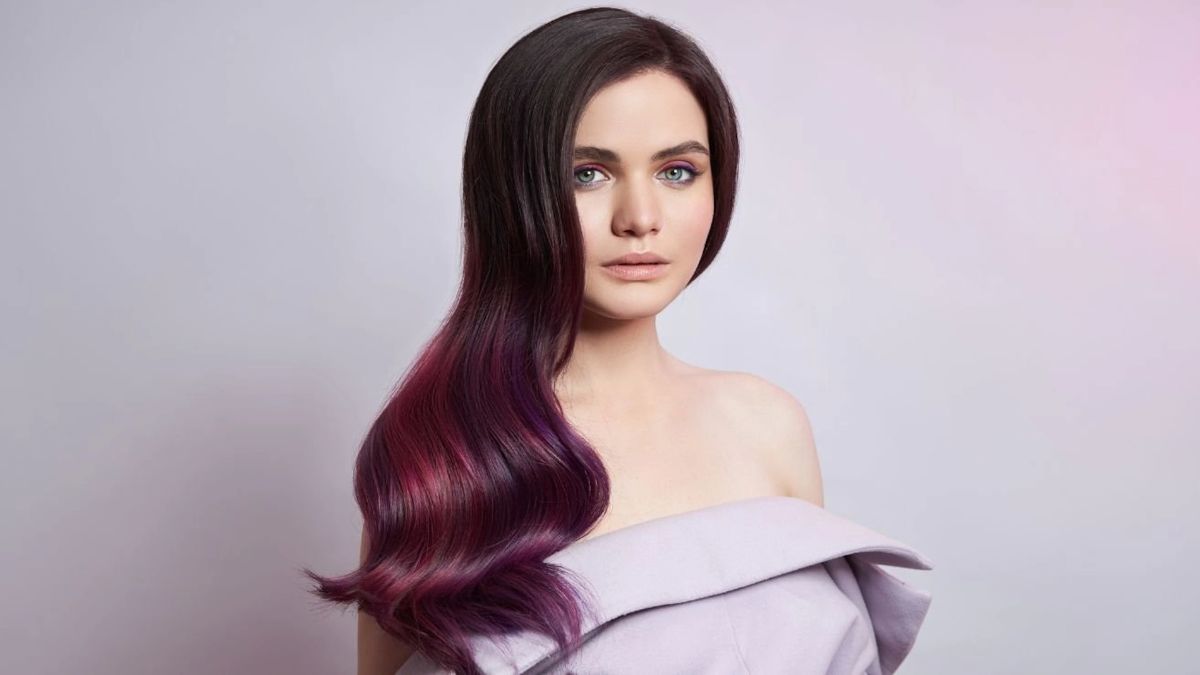 mau-tim-khoi-13 Người phụ nữ với mái tóc dài màu đỏ tím, mặc váy trễ vai màu nhạt, nền màu tím nhạt.