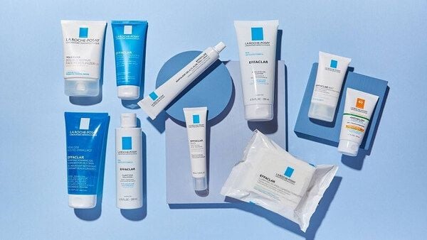 Các sản phẩm chăm sóc da với bao bì màu xanh và trắng, sắp xếp trên nền xanh nhạt.