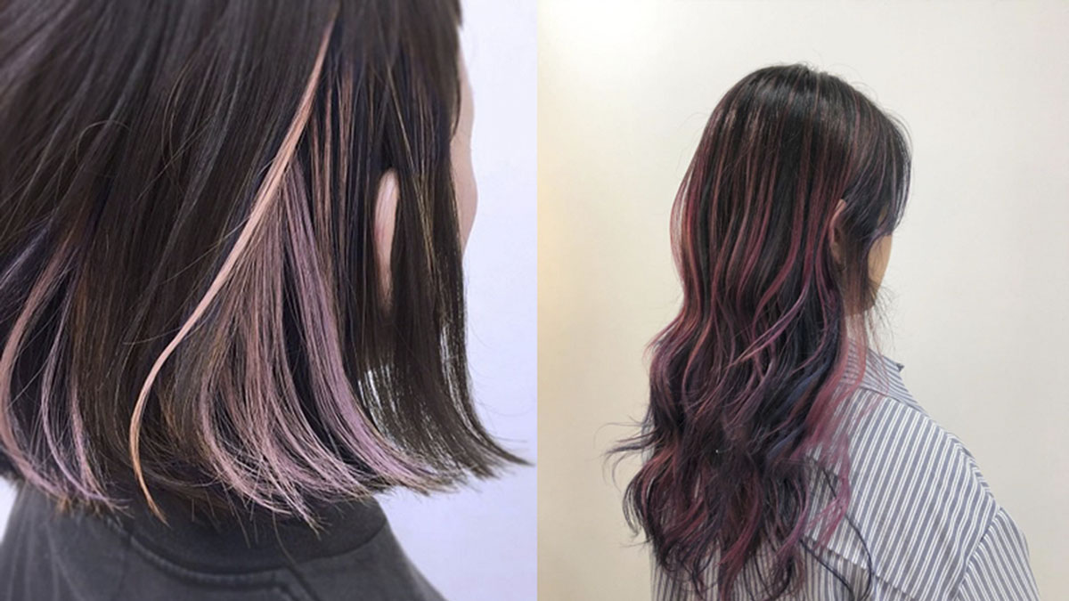 Tóc nhuộm highlight màu hồng trên nền tóc đen, kiểu tóc ngang vai và dài uốn lượn.