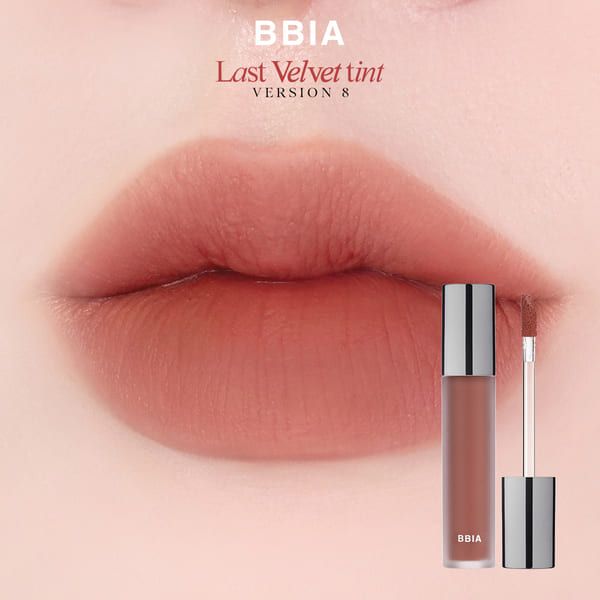 Son môi màu hồng đất với hình ảnh môi được tô son, bên cạnh là lọ son và cọ trang điểm.
