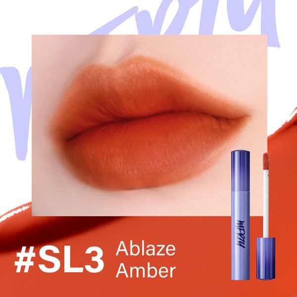 Son môi màu cam đậm trên đôi môi, bên cạnh là thỏi son và đầu cọ, văn bản "#SL3 Ablaze Amber".
