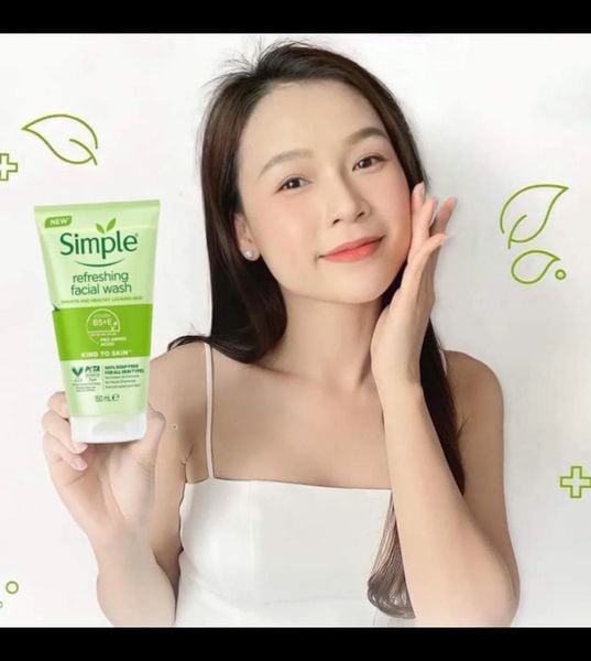 Người phụ nữ cầm tuýp sữa rửa mặt Simple, nền trắng với họa tiết lá cây xanh.