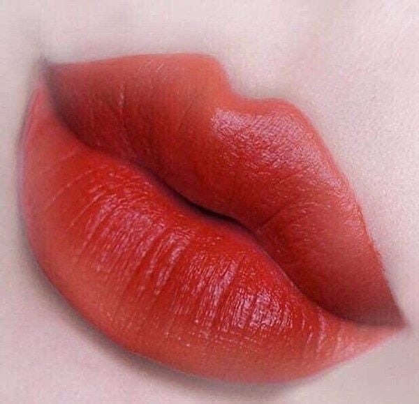 Đôi môi được tô son đỏ đậm, nổi bật trên nền da sáng.