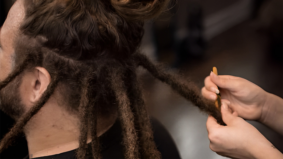 Người đang tạo kiểu tóc dreadlocks cho một người khác trong tiệm làm tóc.
