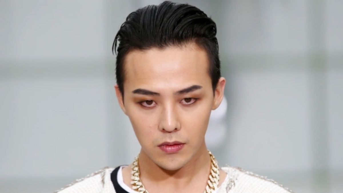 toc-g-dragon-11 Người có mái tóc đen, mặc áo sáng màu và đeo dây chuyền lớn, nhìn thẳng vào máy ảnh.