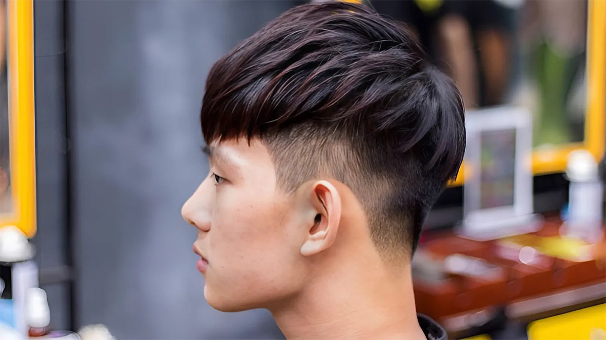 toc-gay-nhon-7 Người đang ngồi trong tiệm cắt tóc, nhìn nghiêng, kiểu tóc undercut gọn gàng.