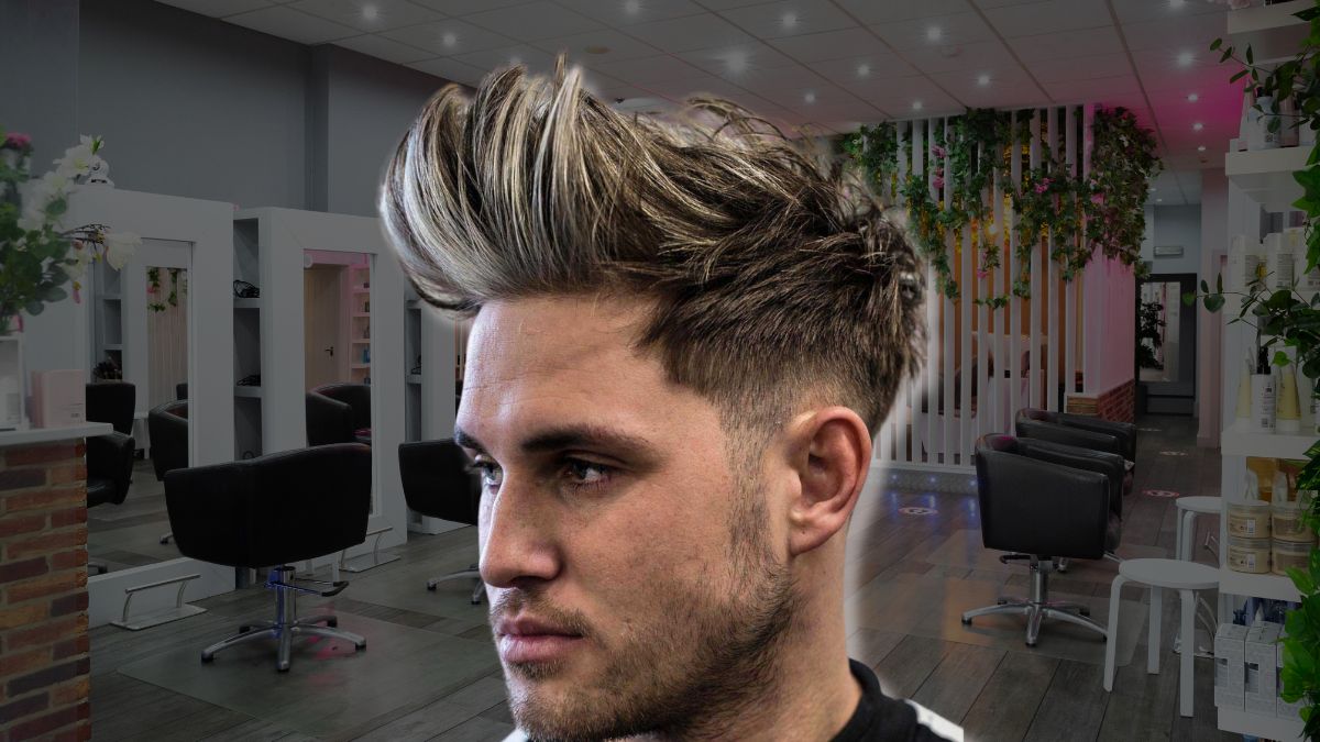 toc-mohawk-10 Người đàn ông với kiểu tóc cắt ngắn hai bên, tóc trên dài vuốt cao, đứng trong tiệm cắt tóc hiện đại.