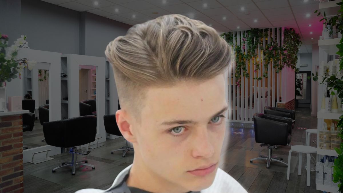 toc-mohawk-13 Người với kiểu tóc undercut đứng trong tiệm cắt tóc hiện đại, trang trí cây xanh và ánh sáng.