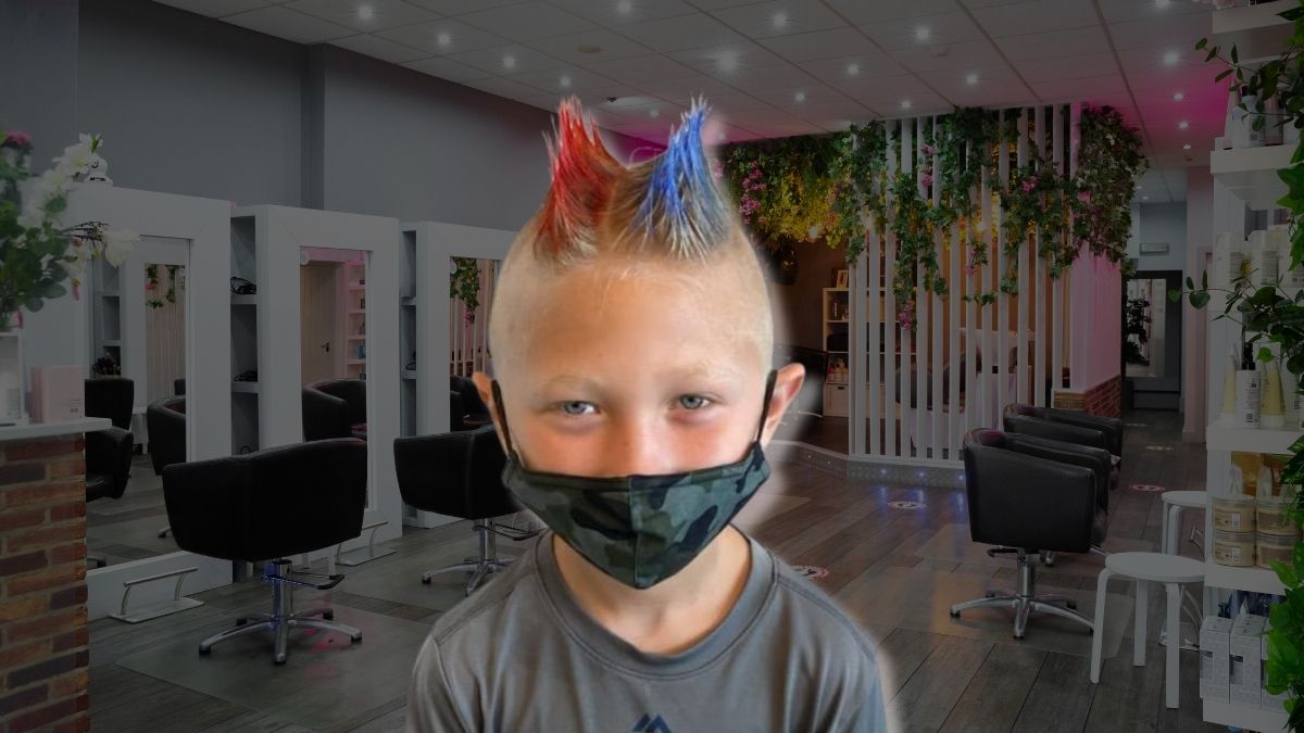 toc-mohawk-17 Người đeo khẩu trang với kiểu tóc dựng nhuộm màu đỏ và xanh, đứng trong một tiệm làm tóc hiện đại.