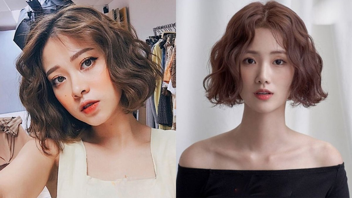 Hai người phụ nữ với kiểu tóc ngắn xoăn nhẹ, đứng trước nền trắng và giá treo quần áo.