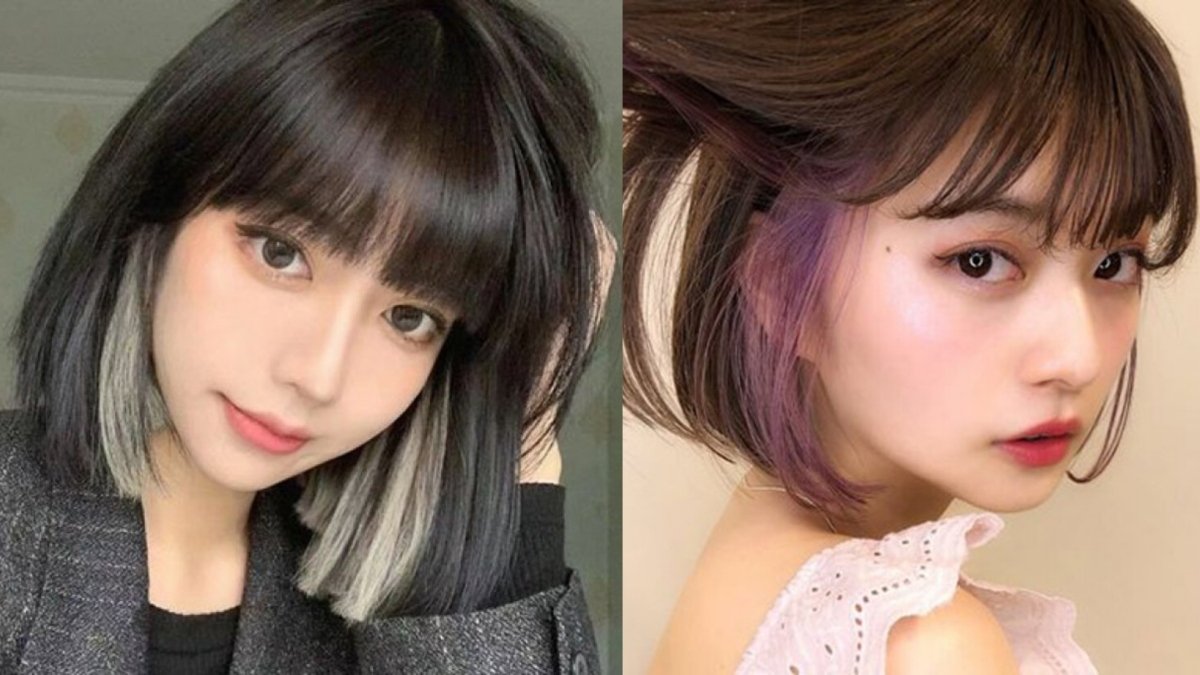 Hai người với kiểu tóc ngắn, một bên nhuộm đen và trắng, bên kia nhuộm nâu và tím, cùng tạo dáng chụp ảnh.