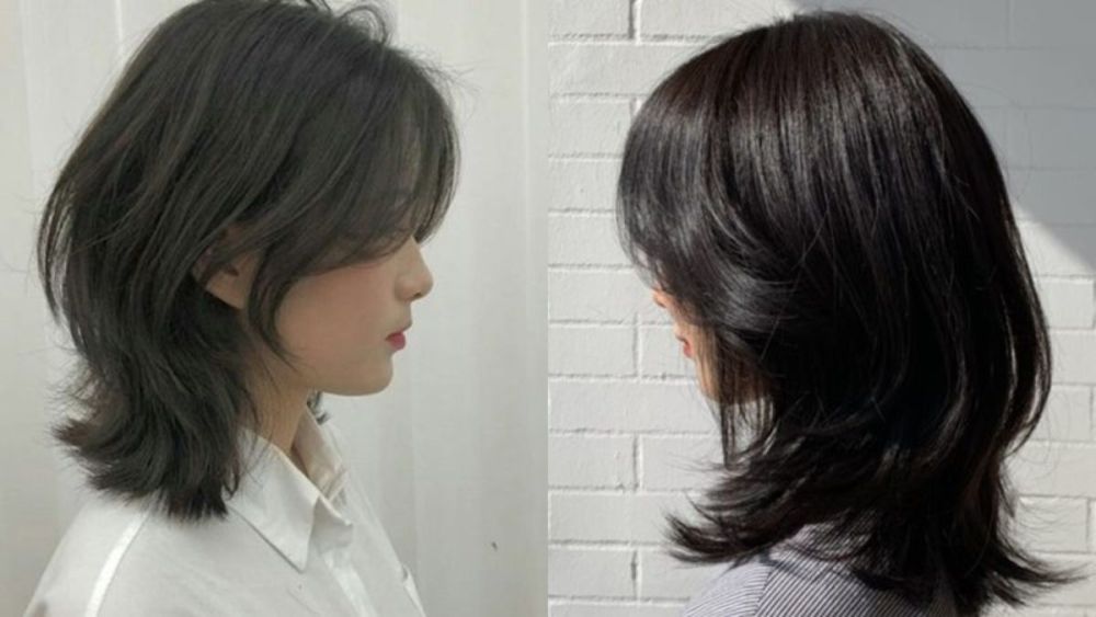 wolf-cut-2 Hai người với kiểu tóc layer ngang vai, nền tường trắng, nhìn nghiêng, một người mặc áo trắng, người kia áo kẻ sọc.